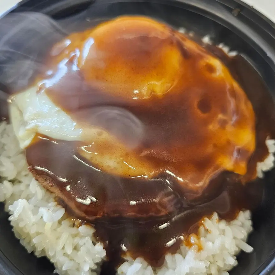 Loco Moco dish with rice, a hamburger patty, and a fried egg, smothered in brown gravy, representing Hawaiian comfort food.